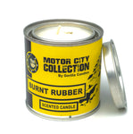 Burnt Rubber candle in a metal tin with a yellow label.