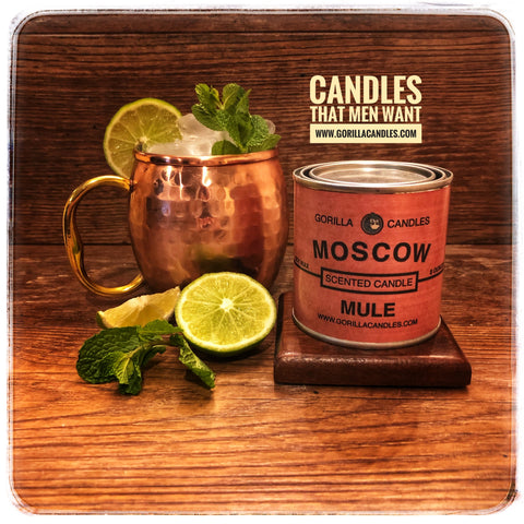 Moscow mule candle in a brass tin next to a prepared Moscow Mule drink