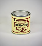 Front view of Hard Cider candle in a metal tin with white labeling 