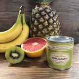 Gorilla Farts candle surrounded by kiwi, grapefruit, bananas, and a pineapple.